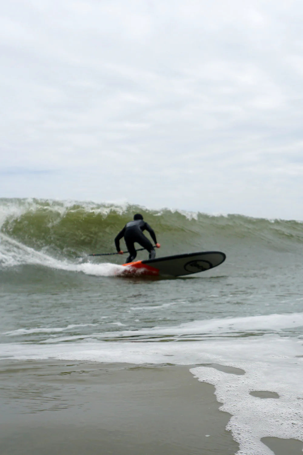 Simon carves a bottom turn on his Amigo Hard Paddle Board