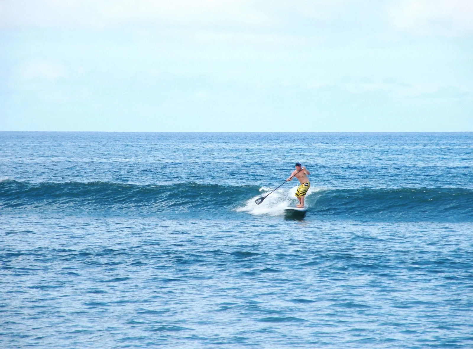 Winter sun paddle surfer on a wave