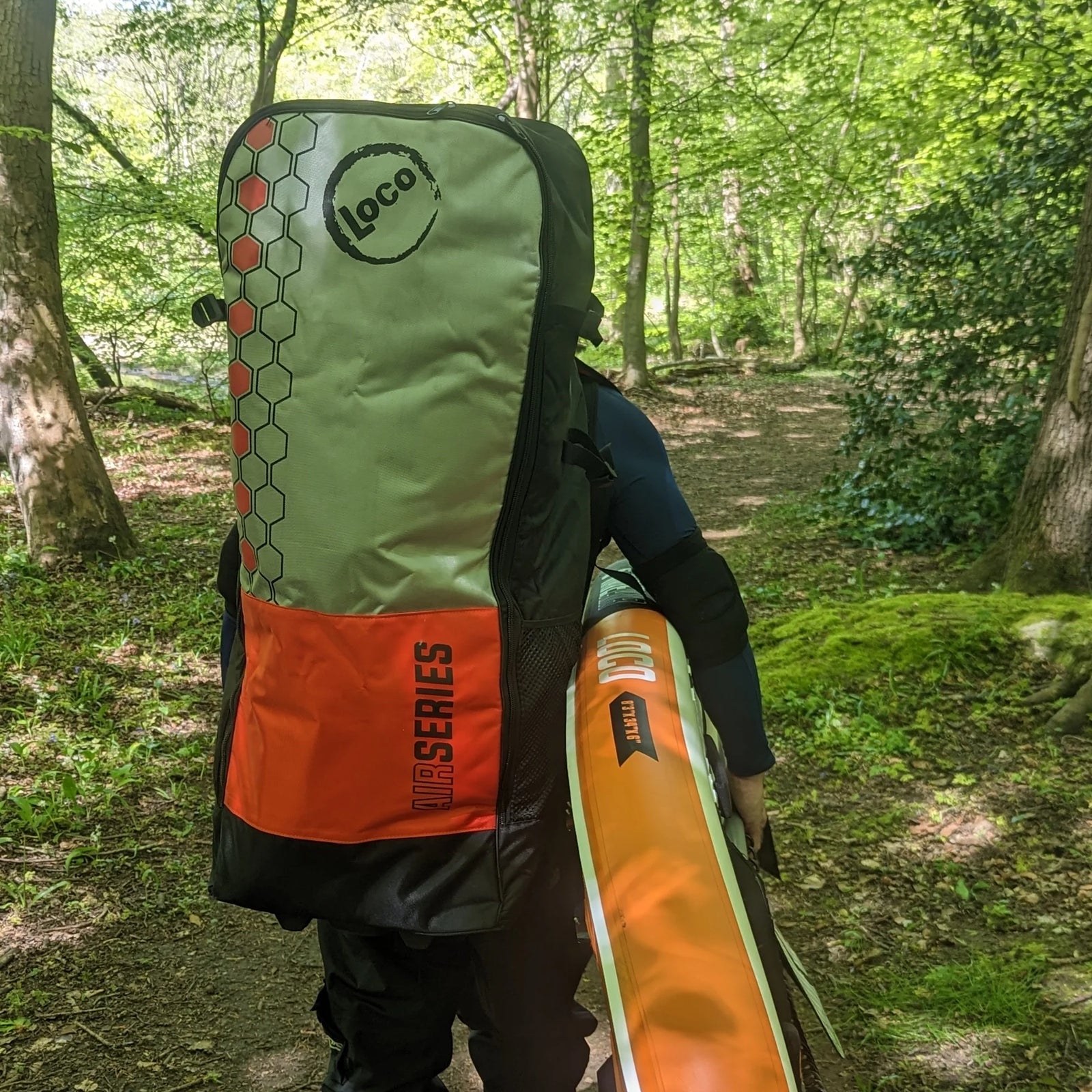 SUP guy Len carrying his paddleboard through an Northumberland forest