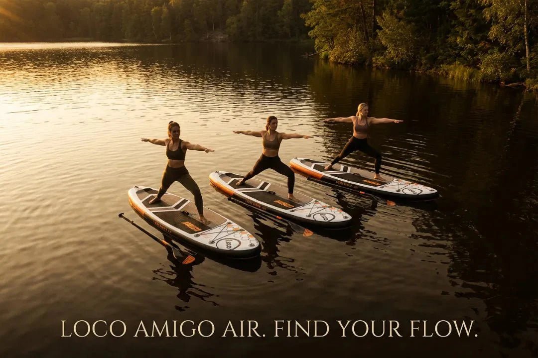 Group of women enjoying SUP yoga on Loco Amigo Air inflatable paddle boards on forest lake at golden hour
