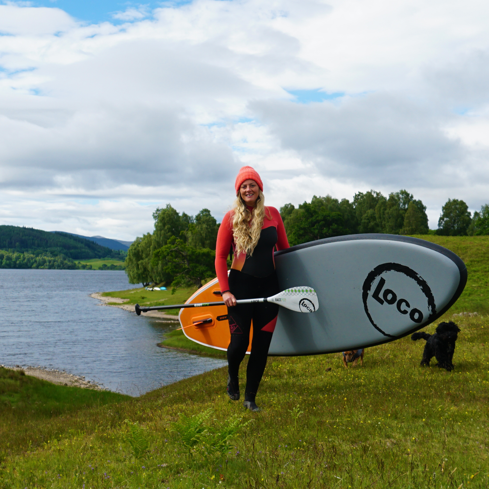 Girl carrying her inflatable paddle board ahead of a session in Scotland