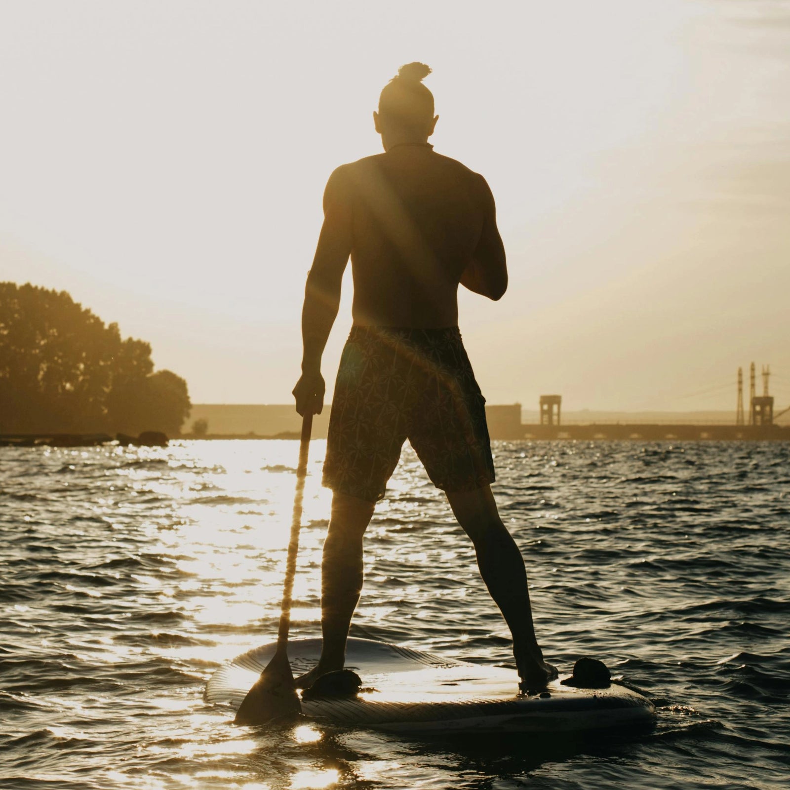 Woman checks here smart phone while paddling her SUP