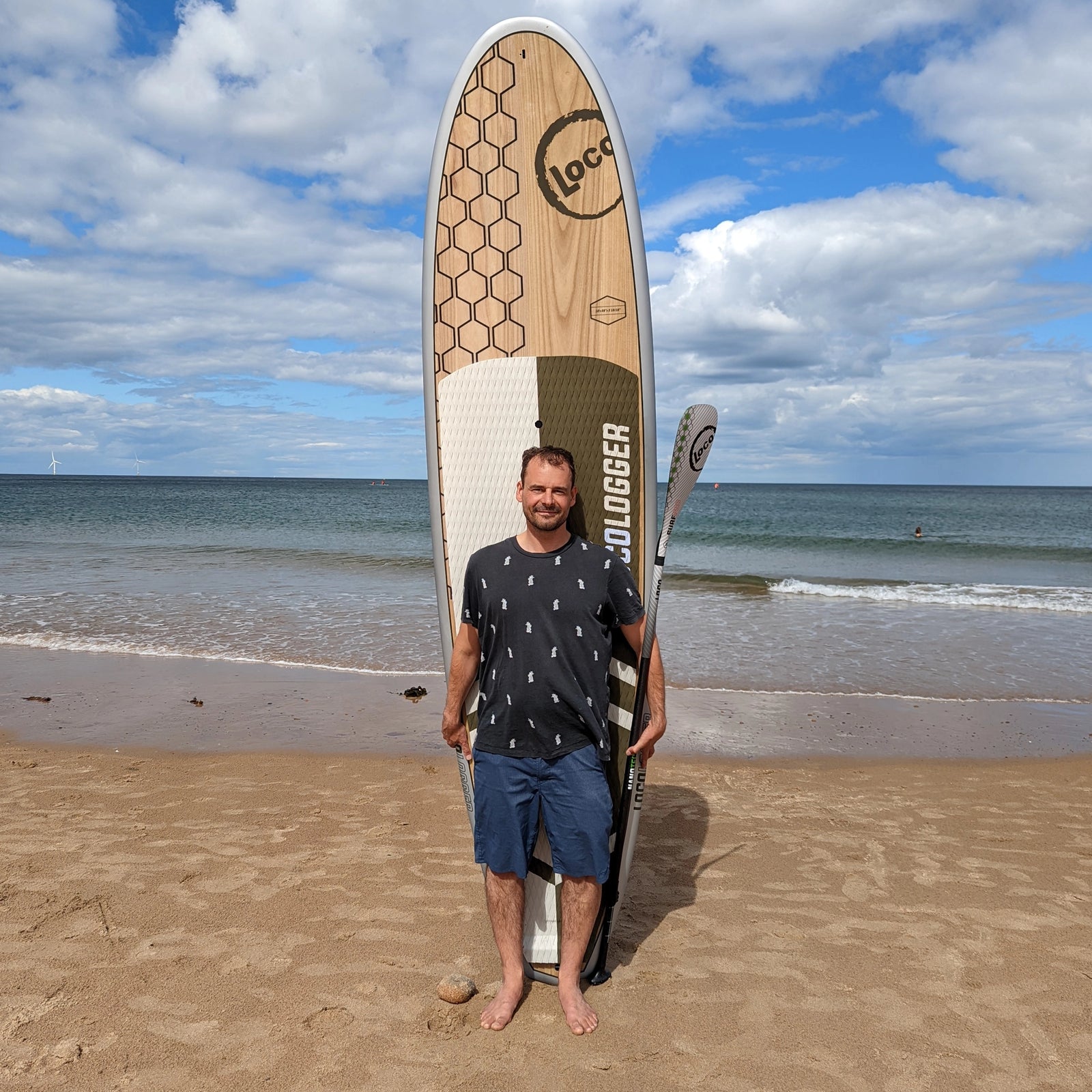Gabe Davies poses with his stand up paddle board