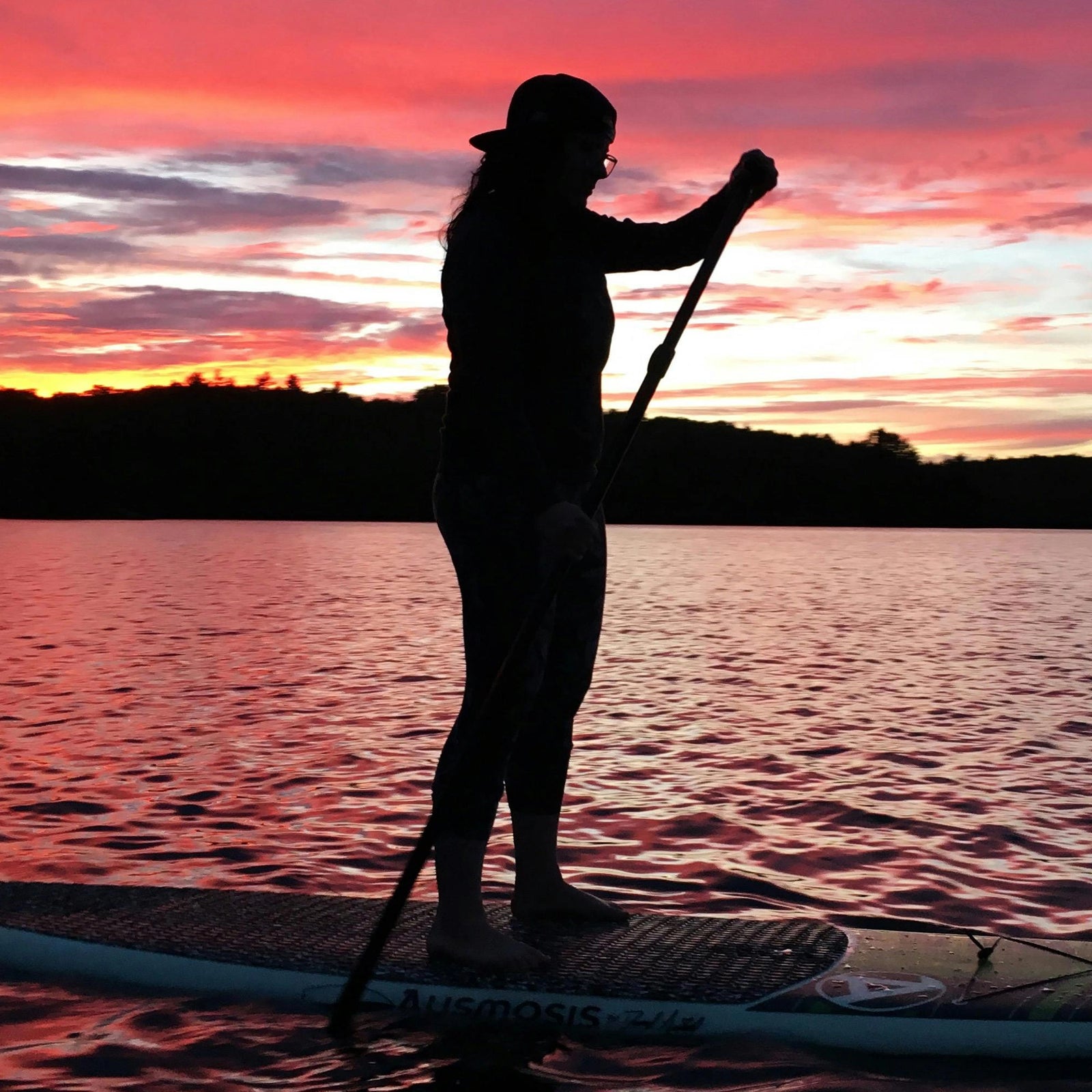 Comprehensive Guide to Selecting the Perfect SUP Paddle, women engaging her paddle board paddle at sunset