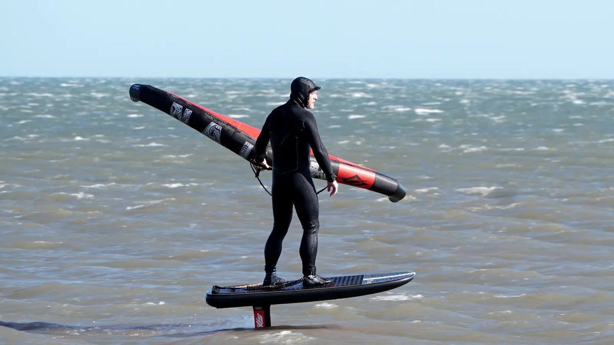 Wing foil rider standing on a stable board in moderate UK wind