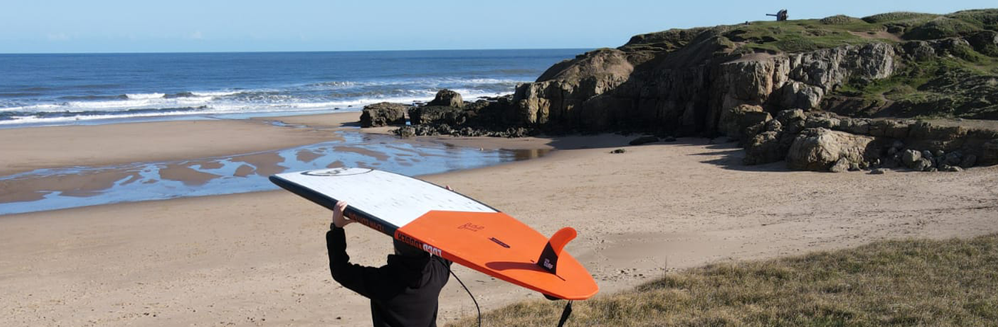 hardboard carried on SUP surfers head