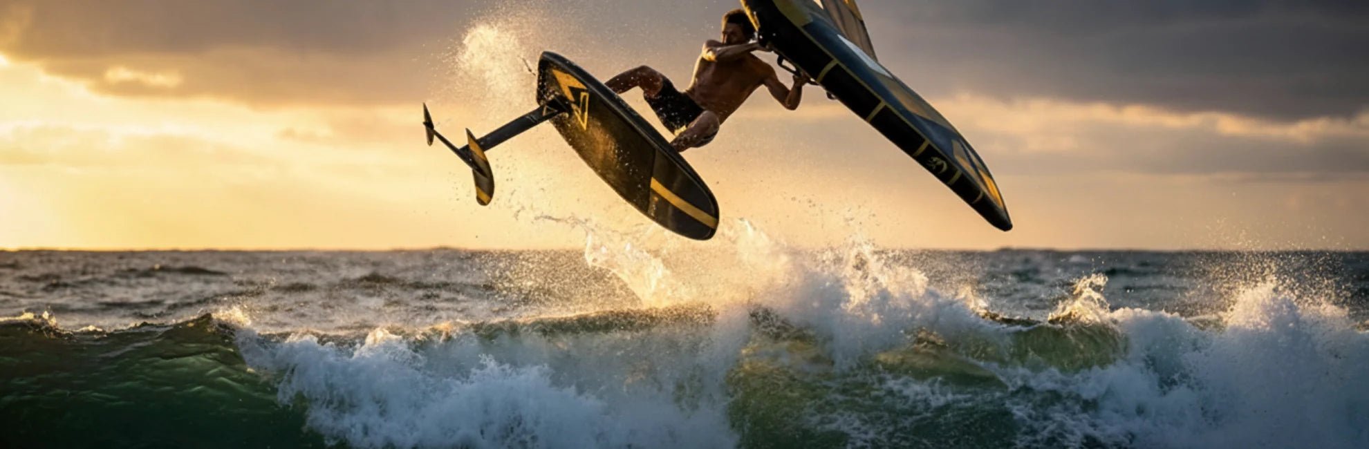 wing foil rider boosting air off a wave at sunset