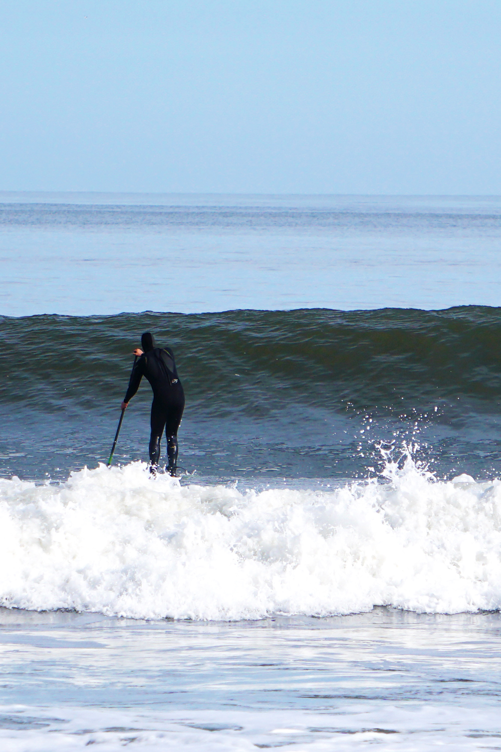 SUP Surfer heads out back 