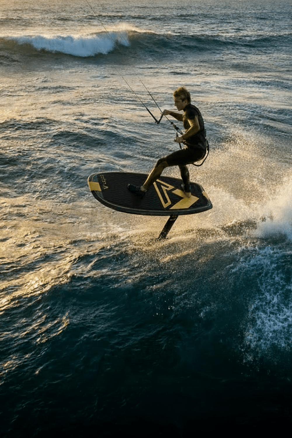 guy kite foiling on a wave at sunset