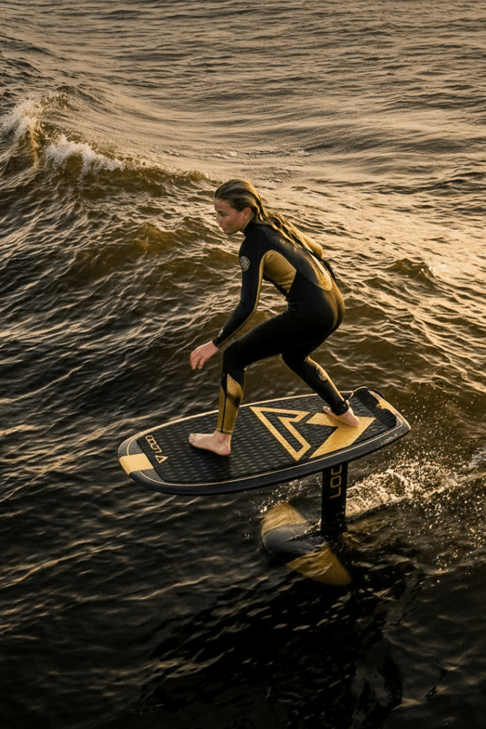 Girl pump foiling on dusk wave at the coast