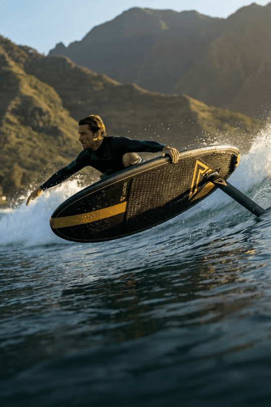 radical surf foil rider grabs a rail on a peeling dusk wave